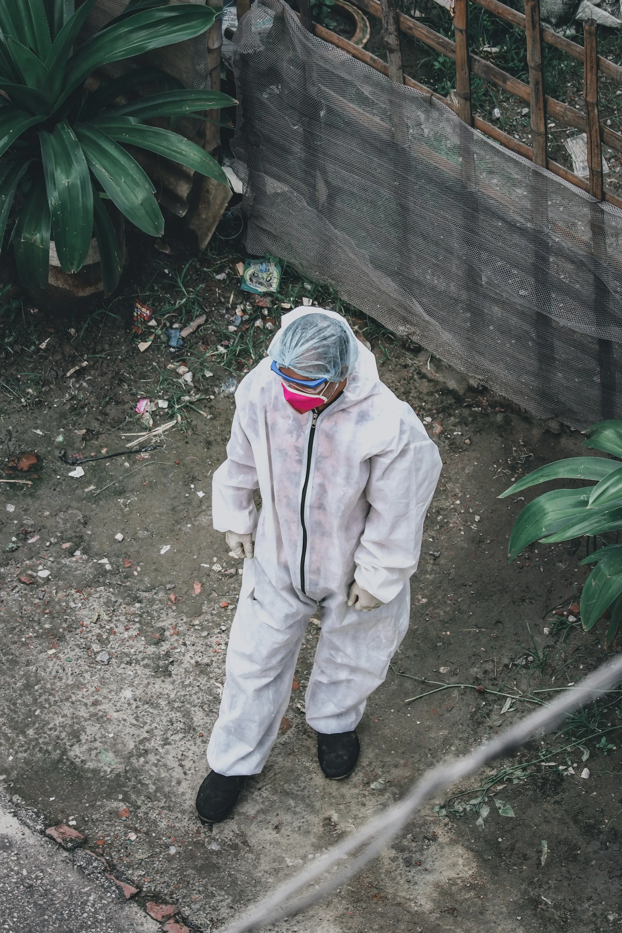 Worker in a disposable coverall, gloves and face covering